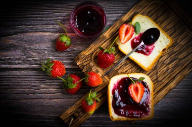 Eski bir arka planda bir bardak ekmeğin içinde çilek reçeli