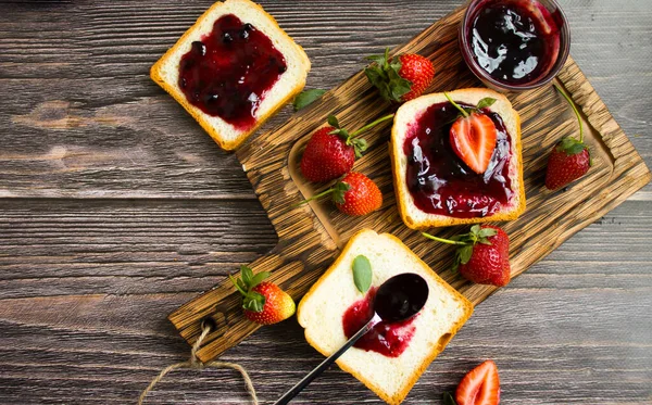 Eski bir arka planda bir bardak ekmeğin içinde çilek reçeli