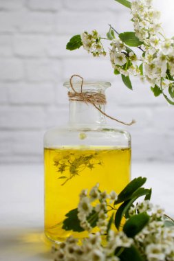 Yasemin çiçeği arkaplanda cam bir şişede özütülüyor.