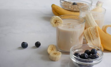 Yoğurt, muz, yulaf ezmesi, sağlıklı kahvaltı içeceği.