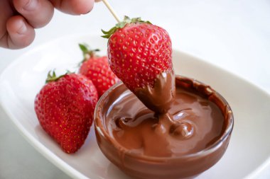 Hafif bir arka planda çikolatalı taze çilekler.