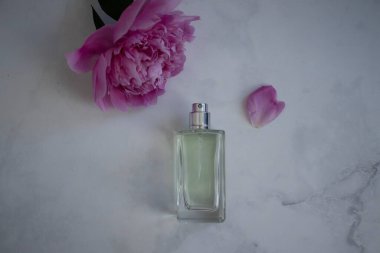 Parfüm şişesi, arka planda şakayık çiçeği.