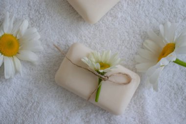 Doğal sabun, açık arkaplanda papatya çiçeği.