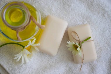 Doğal sabun, açık arkaplanda papatya çiçeği.