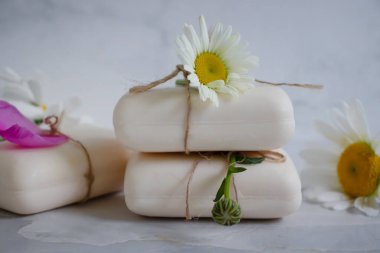 Doğal sabun, açık arkaplanda papatya çiçeği.