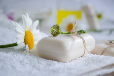 Doğal sabun, açık arkaplanda papatya çiçeği.