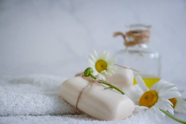 Doğal sabun, açık arkaplanda papatya çiçeği.