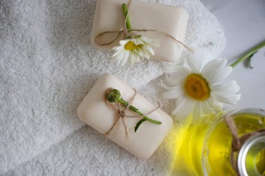 Doğal sabun, açık arkaplanda papatya çiçeği.