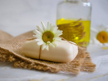 Doğal sabun, açık arkaplanda papatya çiçeği.