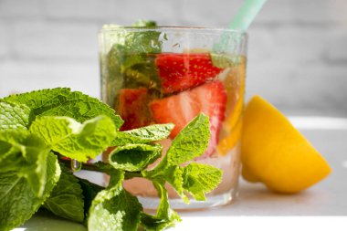 Çilekli limonata, nane, arka planda limon.