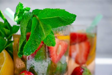 Çilekli limonata, nane, arka planda limon.