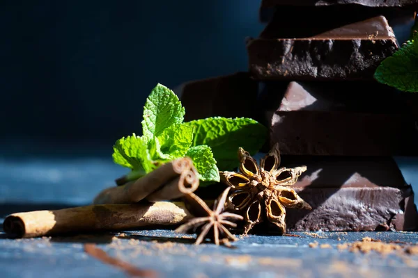 Black chocolate, mint leaf on a dark background