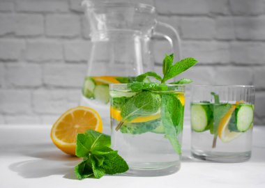 Limonlu su, salatalık, arkaplanda nane.