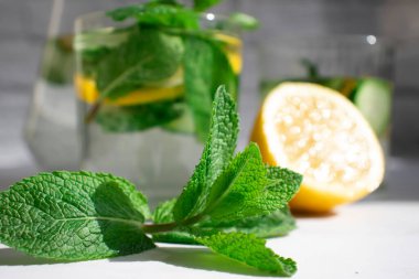 Limonlu su, salatalık, arkaplanda nane.