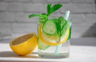 Limonlu su, salatalık, arkaplanda nane.