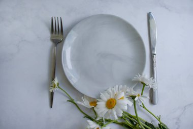 Boş tabak, arka planda papatya çiçeği