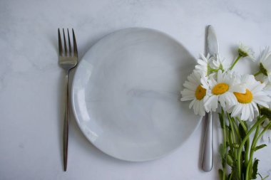 Boş tabak, arka planda papatya çiçeği