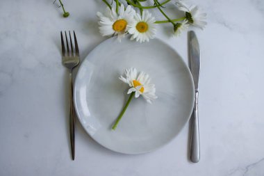 Boş tabak, arka planda papatya çiçeği