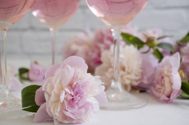 A glass of wine flower peony on a light background