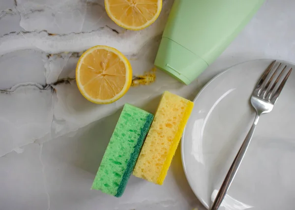Sponge for washing dishes, lemon, plate