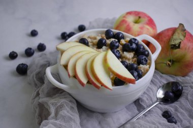 Oatmeal with fresh blueberries, apple, background
