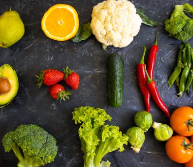 Koyu bir arka planda farklı sebze ve meyveler