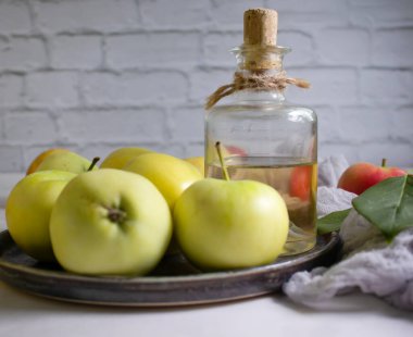 Apple cider vinegar in a bottle, fresh apples