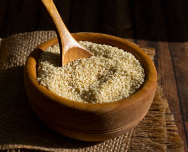 Sesame seeds spoon on old background