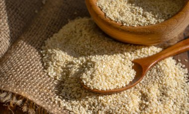 Sesame seeds spoon on old background