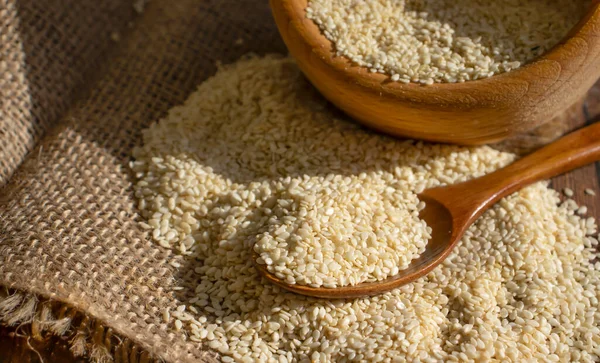 Sesame seeds spoon on old background