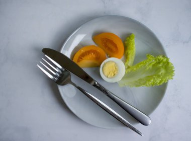 Boiled egg, tomato, lettuce on a diet plate