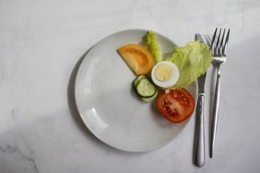 Boiled egg, tomato, lettuce on a diet plate