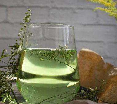 Water with tarragon grass on a light background