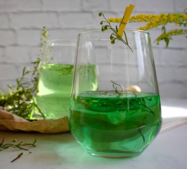 Water with tarragon grass on a light background