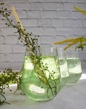 Water with tarragon grass on a light background