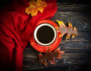 Cup of coffee, autumn leaves on old background, sweater
