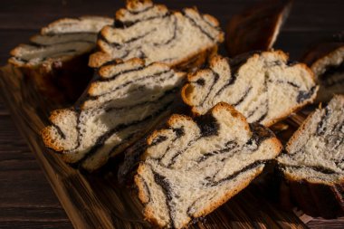 Appetizing bun with poppy seeds on an old background