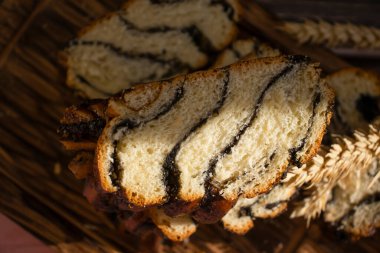 Appetizing bun with poppy seeds on an old background