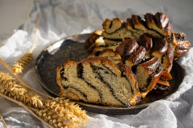 Appetizing bun with poppy seeds on an old background