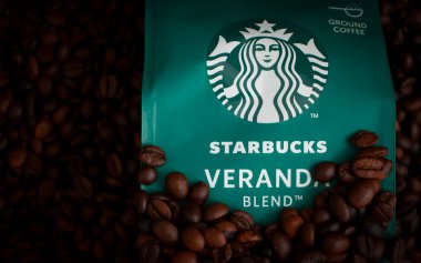 14 Mayıs 2022 Ukrayna şehri Kyiv Starbucks. Ahşap bir arka planda kahve paketi.