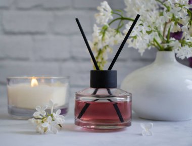 Ev için parfüm, çiçek, arka planda mum