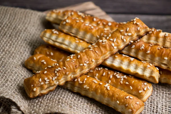 bread sticks with sesame seeds on old background