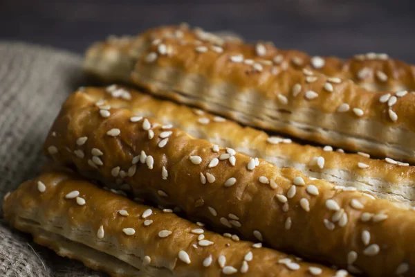 bread sticks with sesame seeds on old background