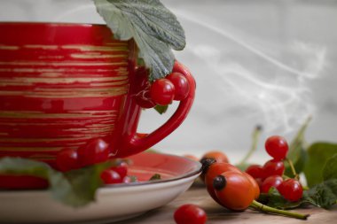 Viburnum 'lu çay, eski bir arka planda gül kalçalı...