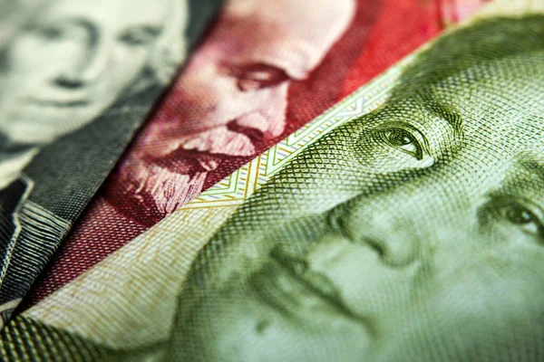Bir Çin yuanı, bir Amerikan doları ve bir Rus rublesinin yakın plan çekimi.