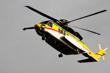 Kıyıdan uzak bir petrol platformunda yakındaki platformlara kabadayılar taşıyan bir helikopter.