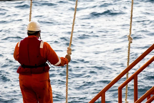 Teçhizat işçileri, Brunei 'deki Güney Çin Denizi' ndeki açık deniz platformlarına naklediliyor. Platforma girmek için bir salıncak ipi kullanılır