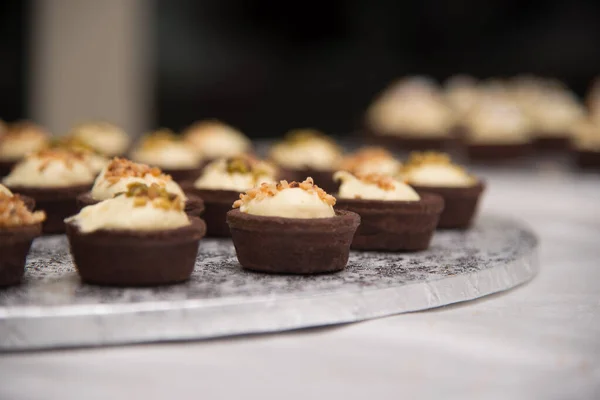 small mignon and single portion desserts. chocolate basket with cream and hazelnuts