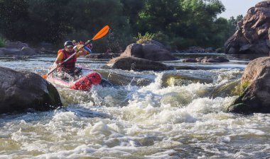 Dağ nehrinin beyaz sularında kürek çeken bir adam. Konsept: ekstrem su sporları, aktif dinlenme, rafting.