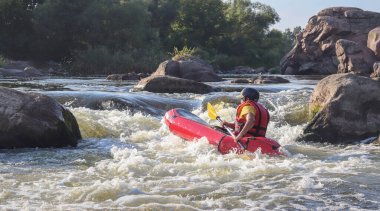 Dağ nehrinin beyaz sularında kürek çeken bir adam. Konsept: ekstrem su sporları, aktif dinlenme, rafting.
